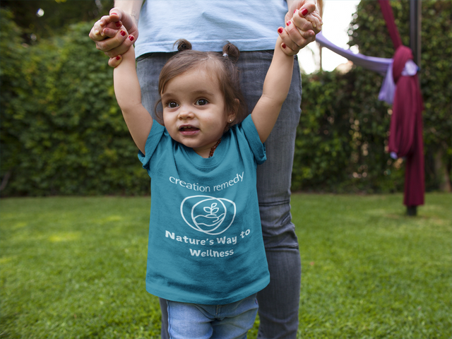 Child smiling in a Creation Remedy shirt, parent-shared photo